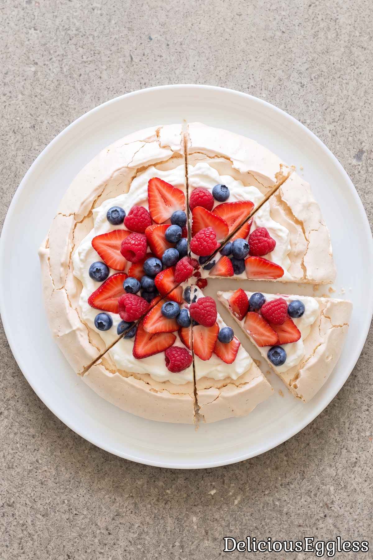 Eggless berry pavlova topped with fresh cream