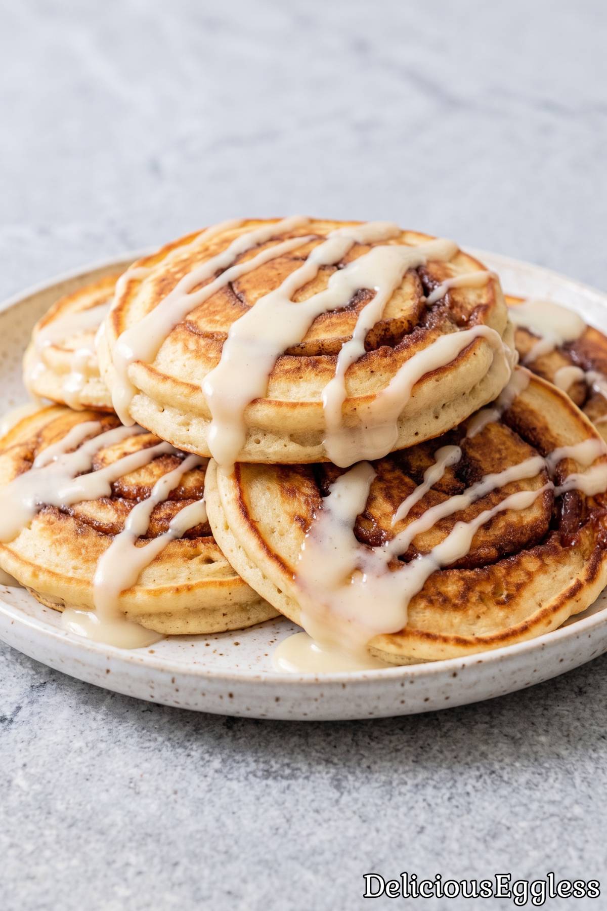 Stack of fluffy eggless cinnamon roll pancakes