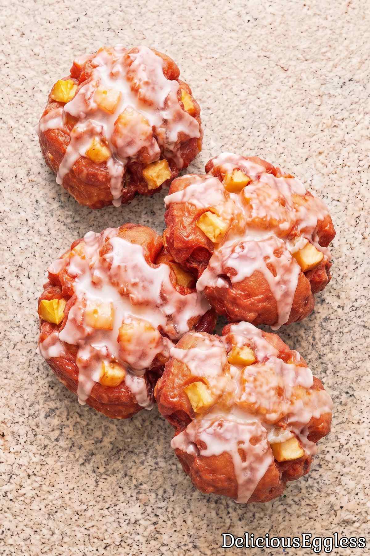 Eggless glazed apple fritters on a plate
