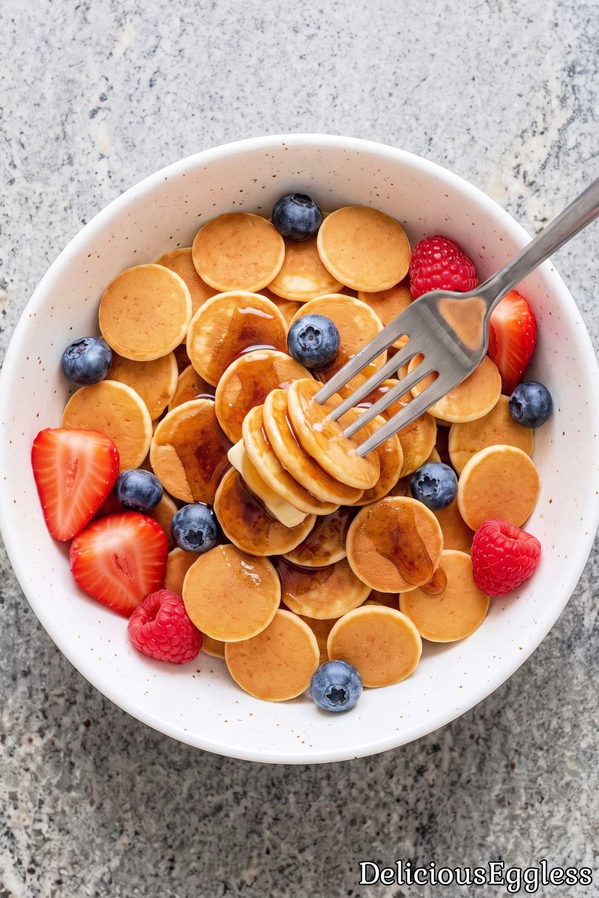 Bowl of warm eggless mini pancake cereal.